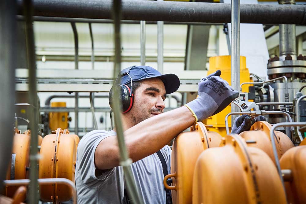 Arbeiter führt seinen Job aus und schraubt an Ventil bei CR3 in Bremen-Industriehäfen